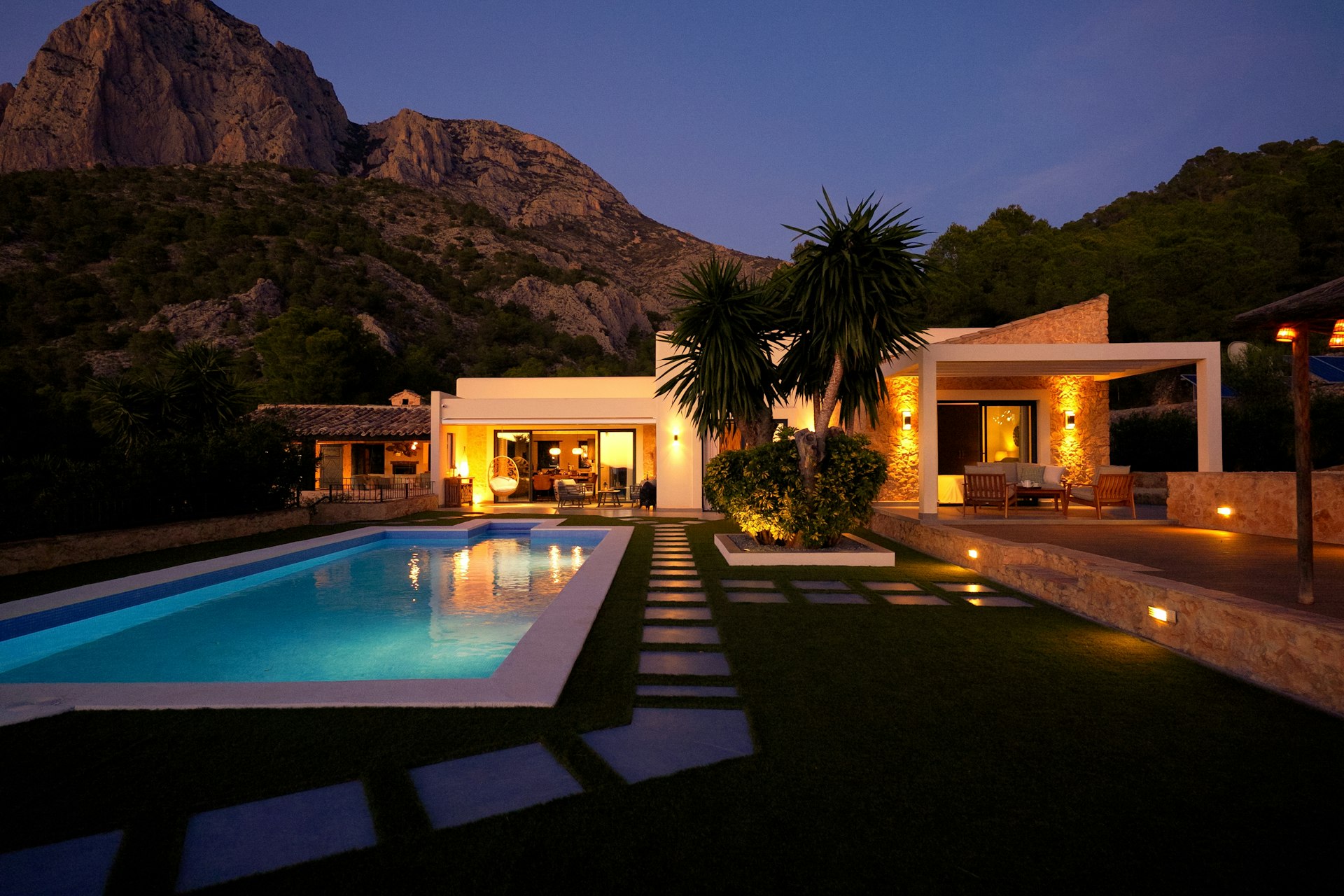 Modern house with pool at dusk near mountain